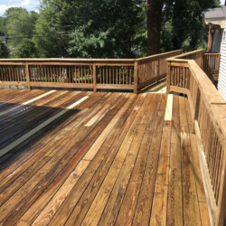 A large, multi-level wooden deck with railings surrounding a house.
