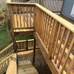 A multi-level wooden deck with stairs and railings.