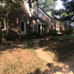A row of traditional brick houses along a sidewalk.