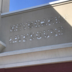 Faded text on a wall reads “KEYBOARDS LIVESOUND” with missing paint on the letters.