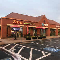 A brick strip mall with storefronts for Zara Mediterranean Charcoal Grill, AT&T, and Smoothie King.