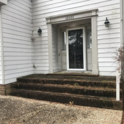 A house entrance with brick steps and the number 12001 above the door.