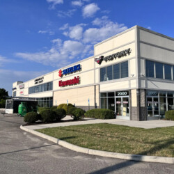 Commonwealth Power Sports storefront featuring Suzuki, Kawasaki, and Victory motorcycle signage.